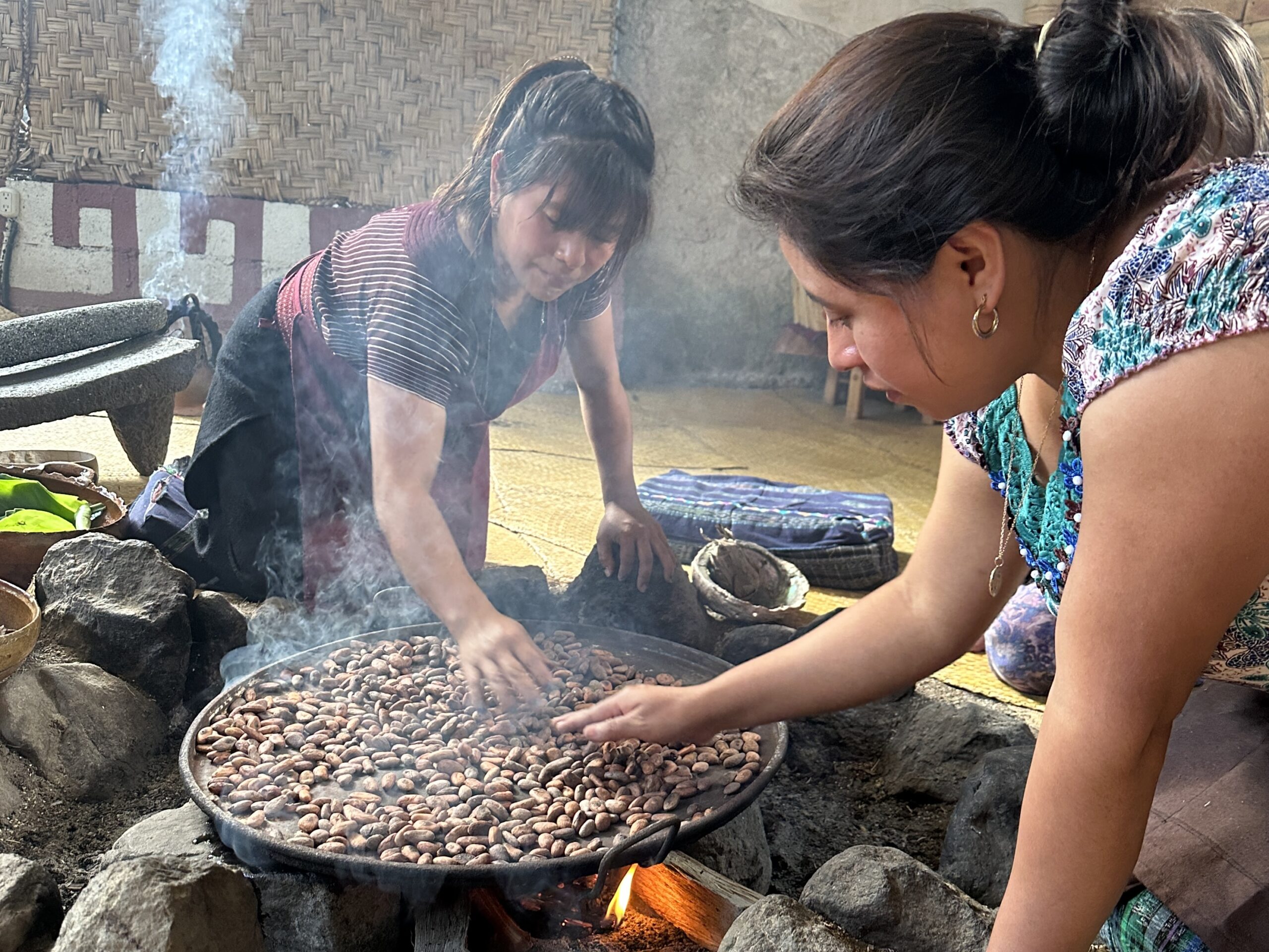 Elizabet and Sayda toasting cacao on comal at Lavalove